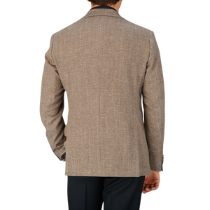 The back view of a man wearing a Eduard Dressler brown herringbone cotton-linen blend tan blazer.