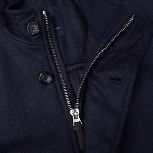A close-up of a zipper on a Eduard Dressler Dark Blue Wool Technical Down Car Coat.
