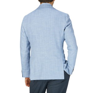 The back view of a man wearing an Eduard Dressler Light Blue Herringbone Cotton Linen Sendrik Blazer.