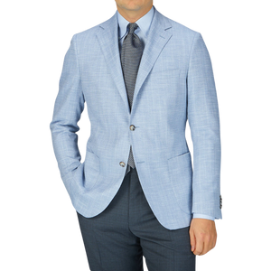 A man wearing an Eduard Dressler Light Blue Herringbone Cotton Linen Sendrik Blazer.
