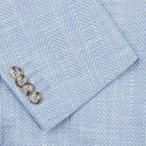 A close up of a Eduard Dressler Light Blue Herringbone Cotton Linen Sendrik Blazer with buttons.