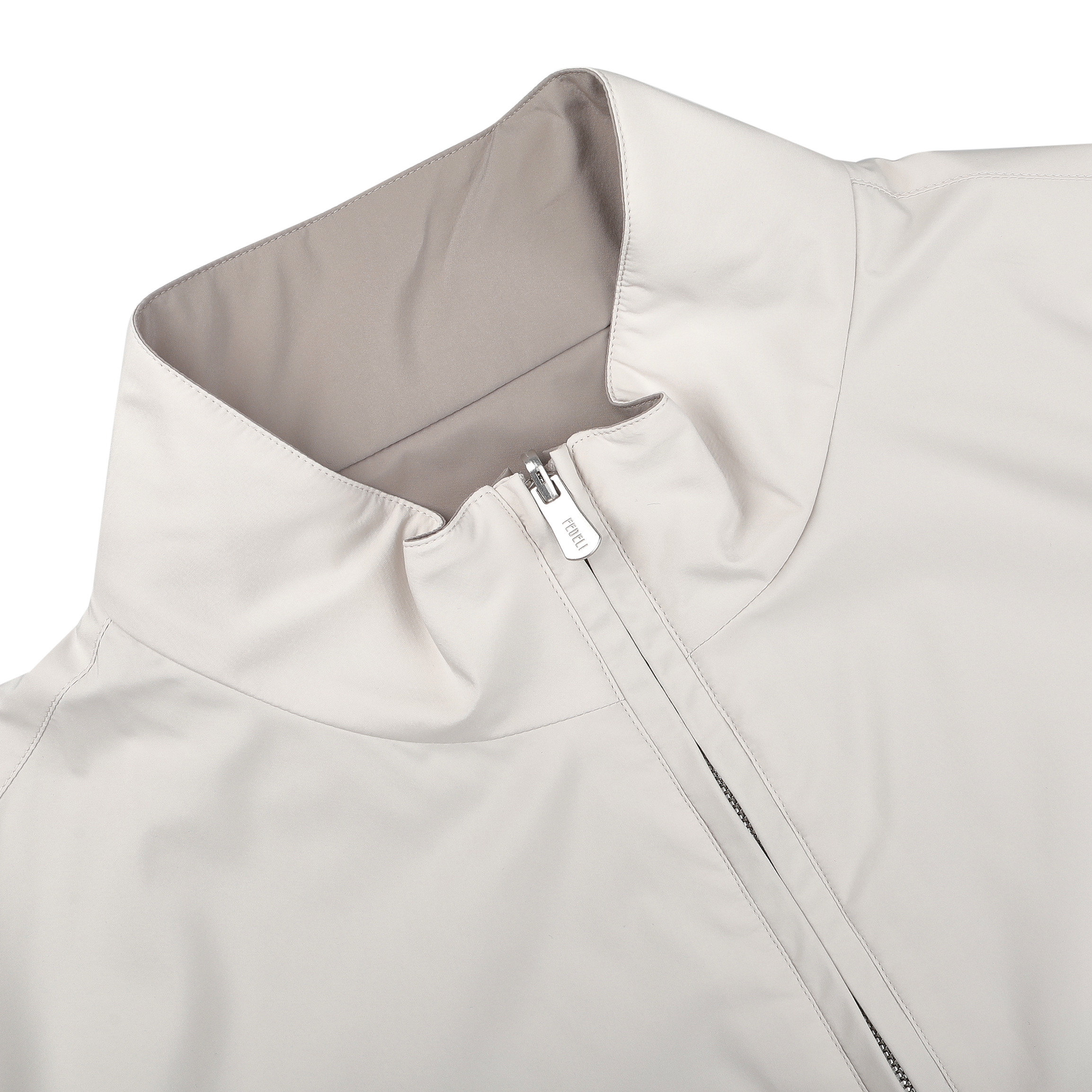 A close-up of the Fedeli Beige Nougat Nylon Reversible Blouson Jacket highlights its water-resistant material, high collar, and partially unzipped front. This regular fit piece balances style and functionality perfectly.