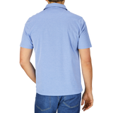 Man wearing a slim fit, blue Fedeli Fil-a-Fil Cotton Jersey Polo Shirt and jeans, viewed from behind.