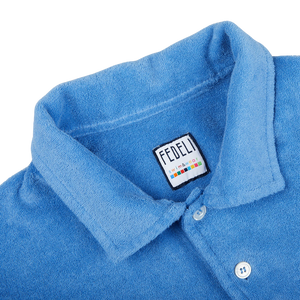 A summer favorite Fedeli Bright Blue Cotton Towelling Polo Shirt with a label on the collar.