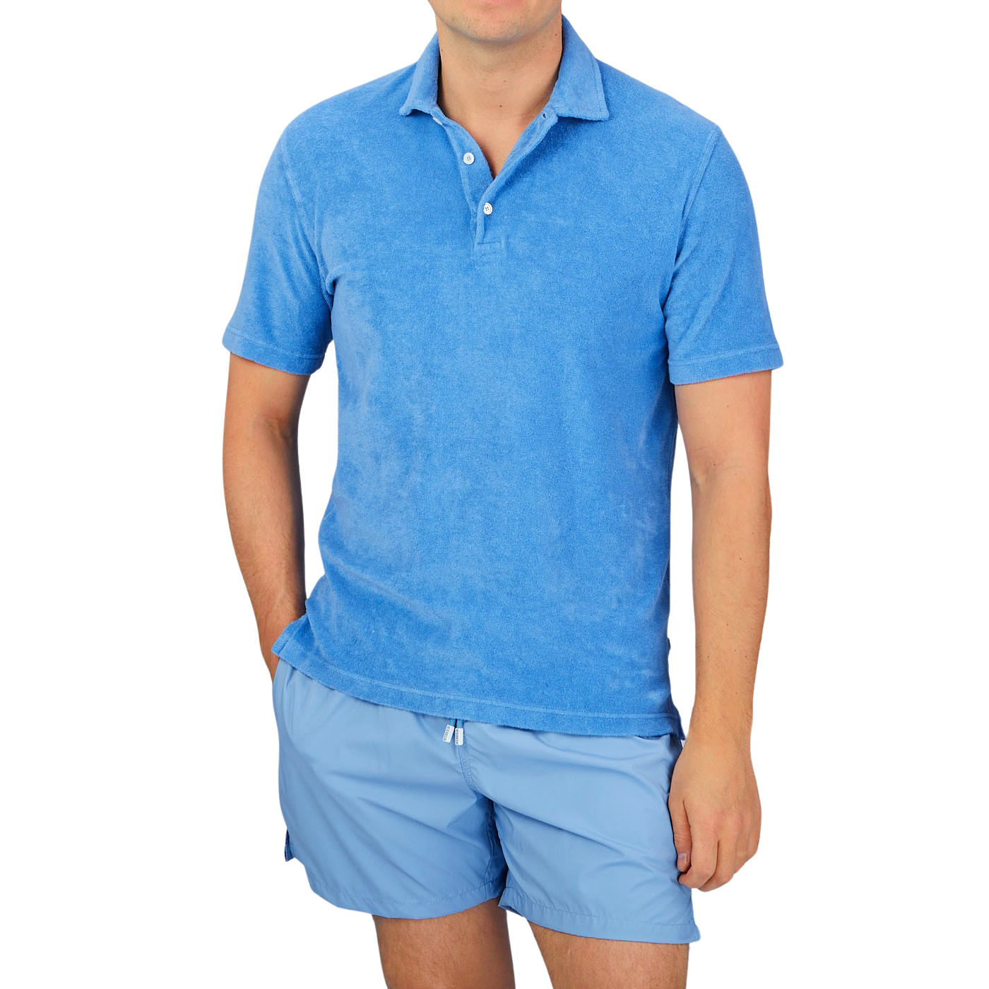 A man wearing a Fedeli Bright Blue Cotton Towelling Polo Shirt and shorts, his summer favorite.