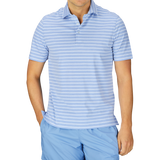 Man in a Contemporary Blue Wide Striped Cotton Jersey Polo Shirt by Fedeli, slim fit, with light blue and white stripes and blue pants. Made in Italy.