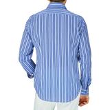 A person from behind wearing a Fedeli Dark Blue Striped Cotton Beach Shirt with white pants.