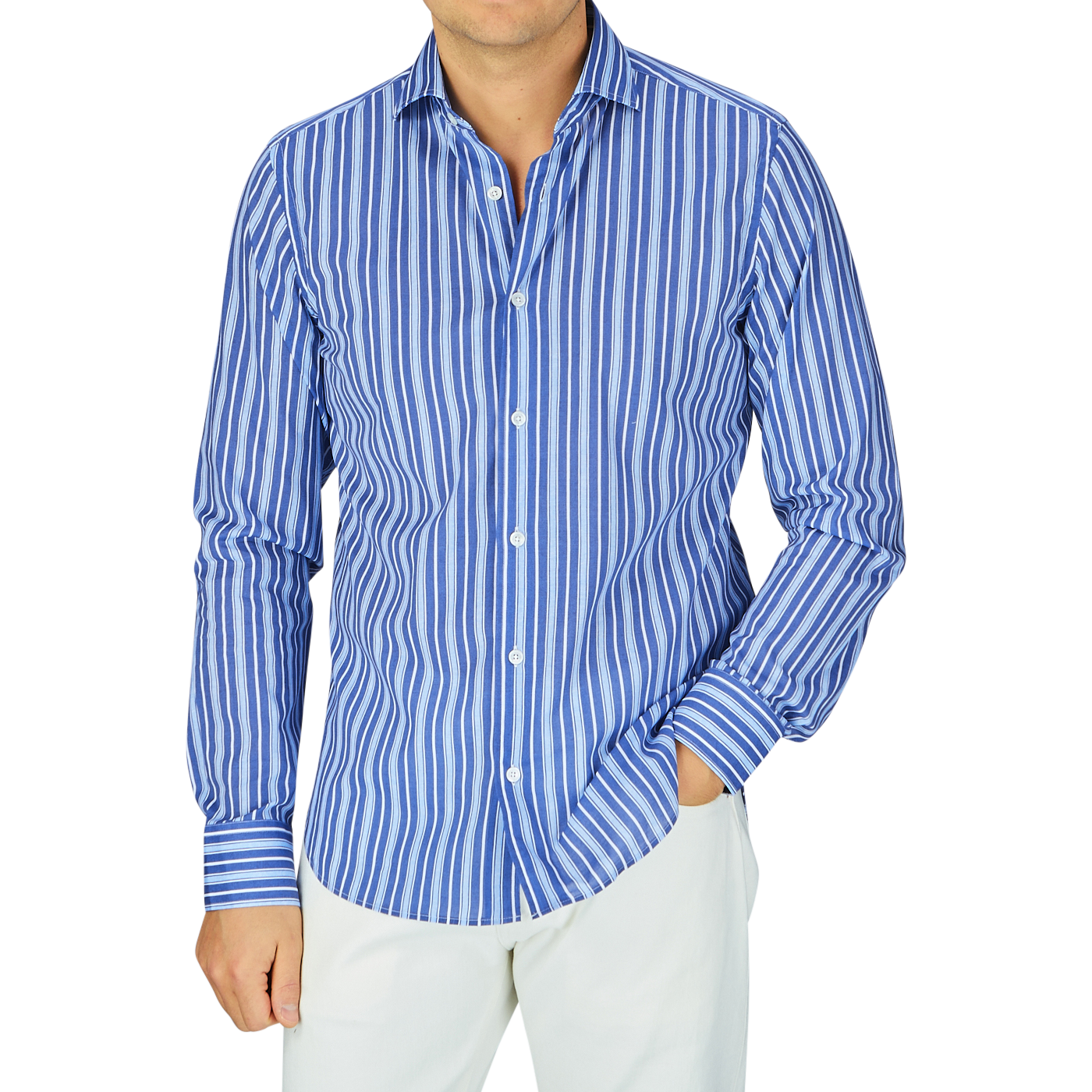 A man wearing a Fedeli dark blue striped cotton beach shirt with the sleeves rolled up, paired with white pants.