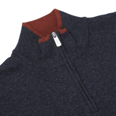 Close-up of the Fedeli Dark Blue Wool Cashmere 1/4 Zip Sweater, crafted from a luxurious wool-cashmere blend. This sophisticated piece features a silver zipper pull and a contrasting red collar detail. It's perfect as a layering piece for added warmth and style.