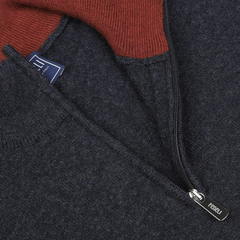 Close-up of the Fedeli Dark Blue Wool Cashmere 1/4 Zip Sweater featuring a red collar and zipper. A blue label with white text is partially visible near the collar, and the zipper pull has "PERAL" engraved on it. This versatile layering piece boasts a luxurious wool-cashmere blend, adding both comfort and elegance to your wardrobe.