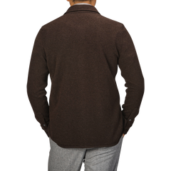 A person viewed from the back is wearing a Dark Brown Felted Cashmere Overshirt by Fedeli, paired with light gray pants.