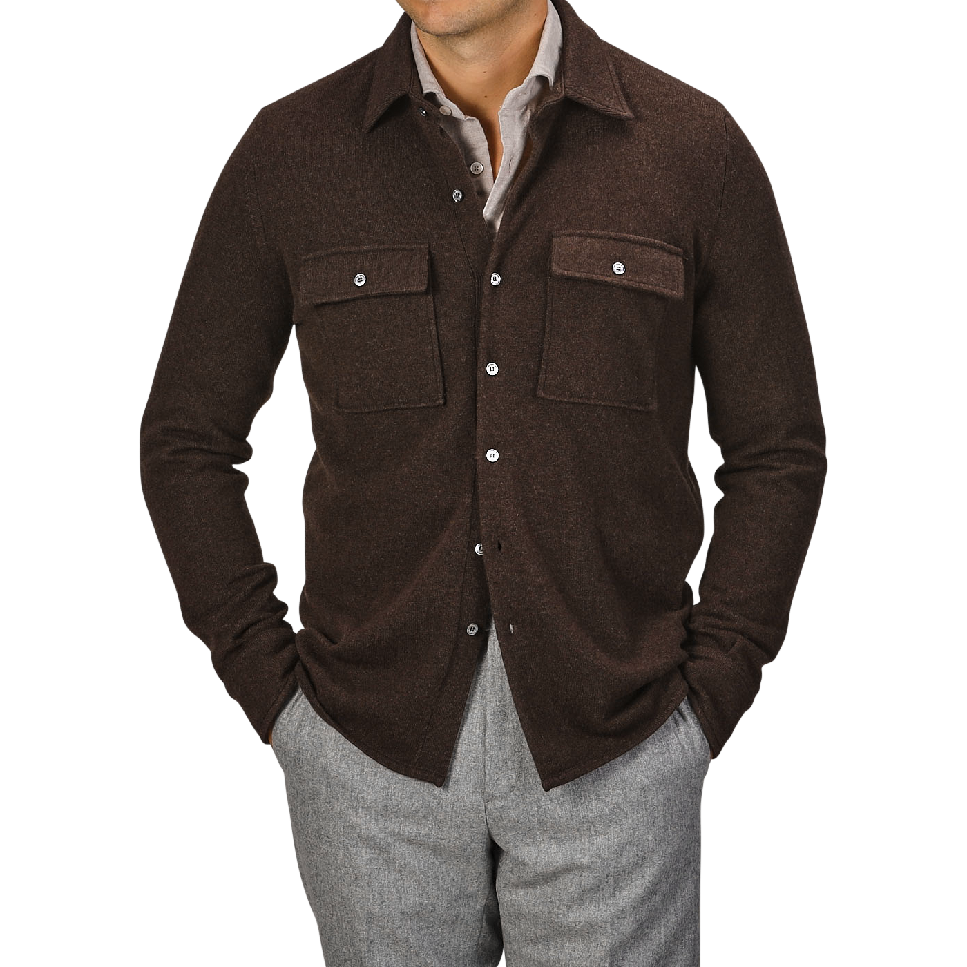 A man wearing a Fedeli Dark Brown Felted Cashmere Overshirt with front pockets and gray trousers, hands casually tucked in his pockets.