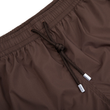 A close-up of a pair of luxurious dark brown Fedeli Madeira swim shorts.