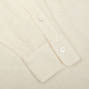 Close-up of a Fedeli Ecru Cotton Linen Piquet Polo Shirt collar with a buttoned cuff.