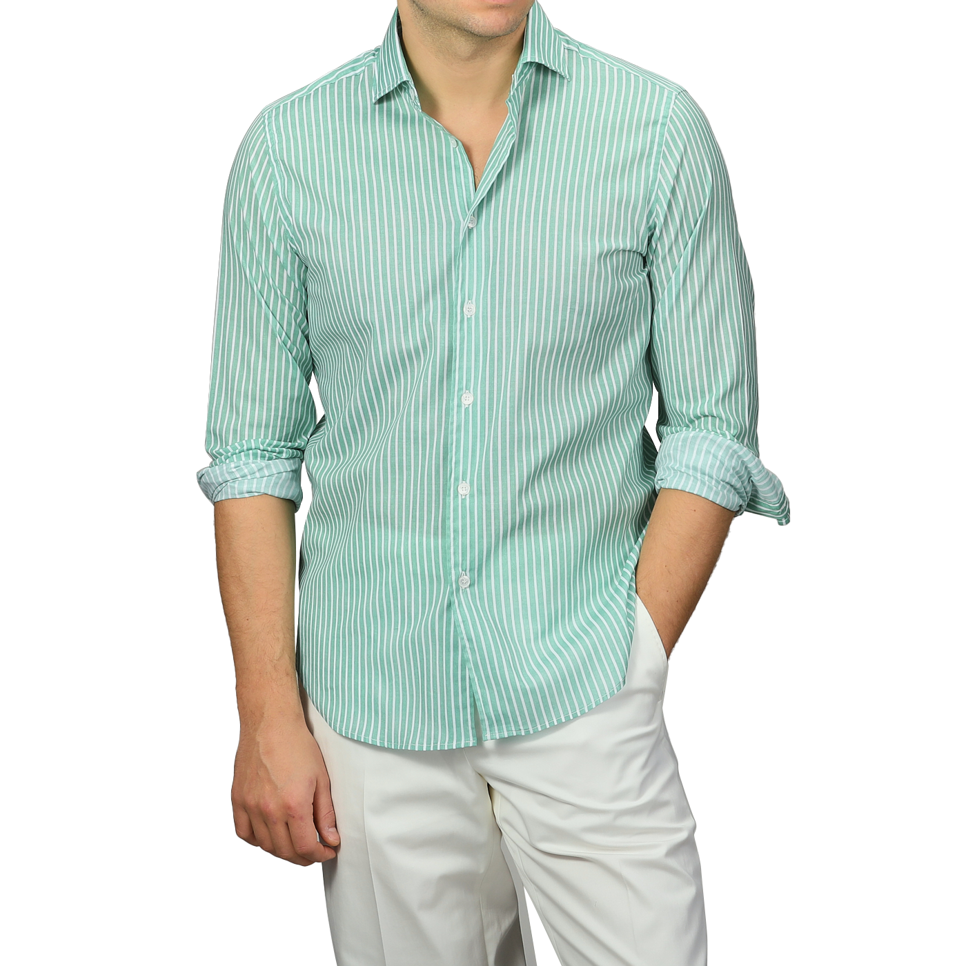 A person sporting a Fedeli Green White Striped Cotton Beach Shirt with rolled-up sleeves and slim-fit white pants stands with one hand in their pocket.