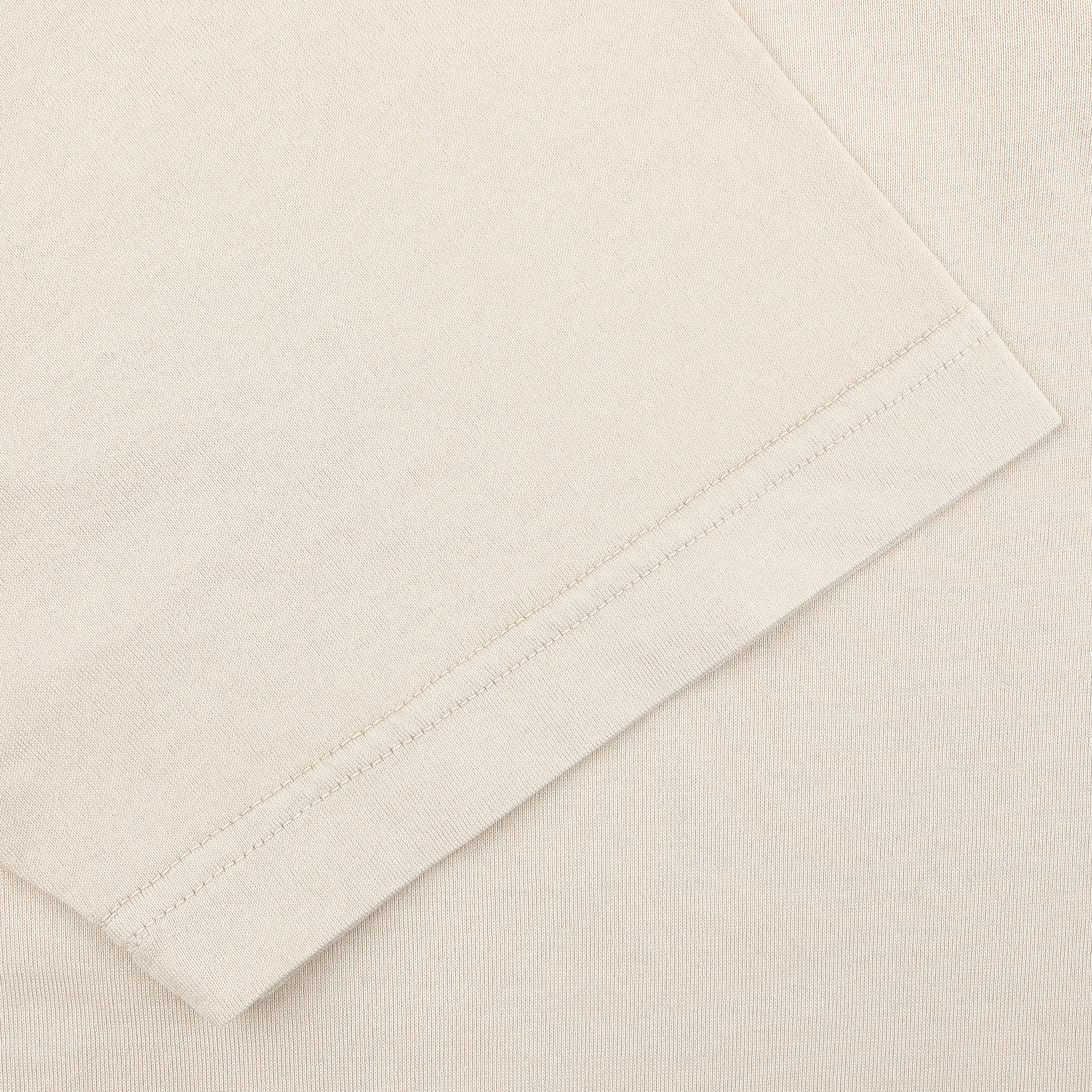 Close-up of the sleeve and shoulder seam of a luxurious casual-wear polo shirt by Fedeli, in light beige, featuring organic cotton and a Capri collar.