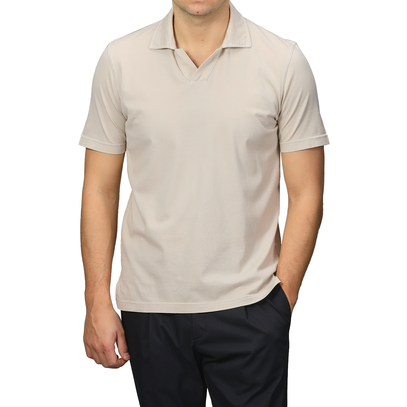 A person wears the Light Beige Organic Cotton Capri Collar Polo Shirt by Fedeli, with dark pants, one hand in the pocket, and faces forward.