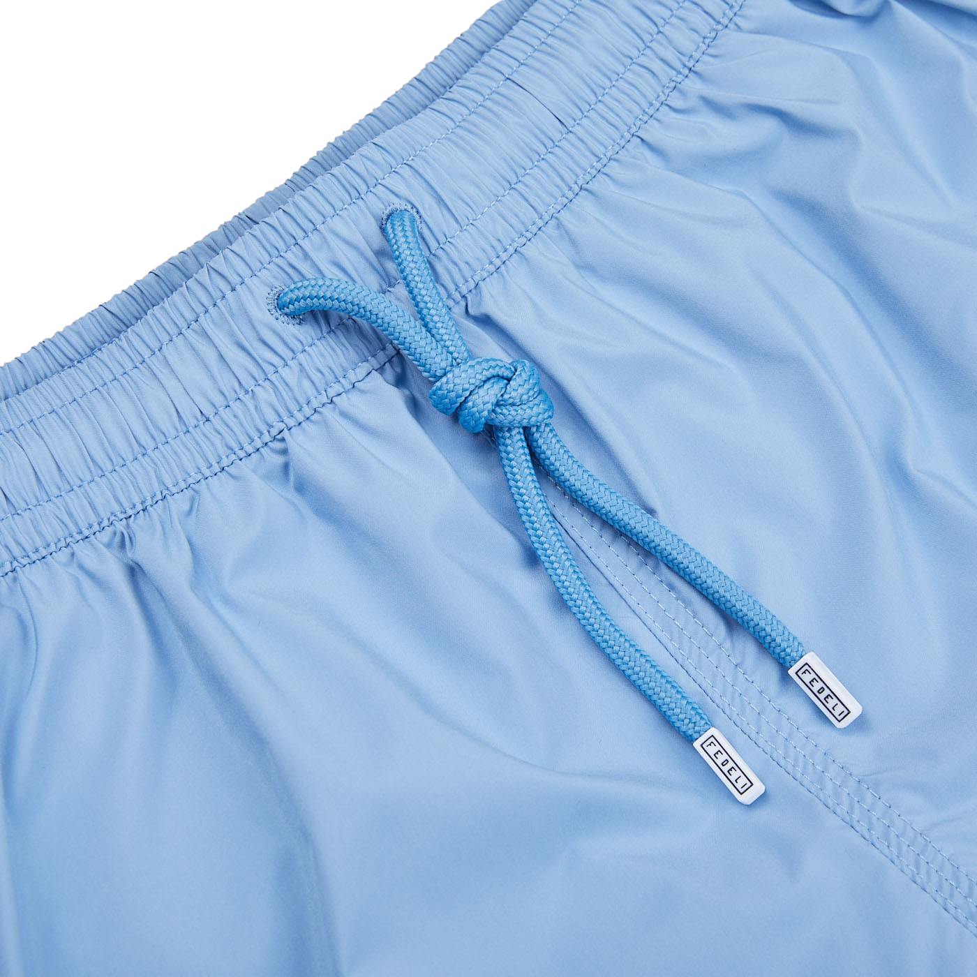 A luxurious pair of Fedeli Light Blue Microfiber Madeira swim shorts with a blue drawstring.
