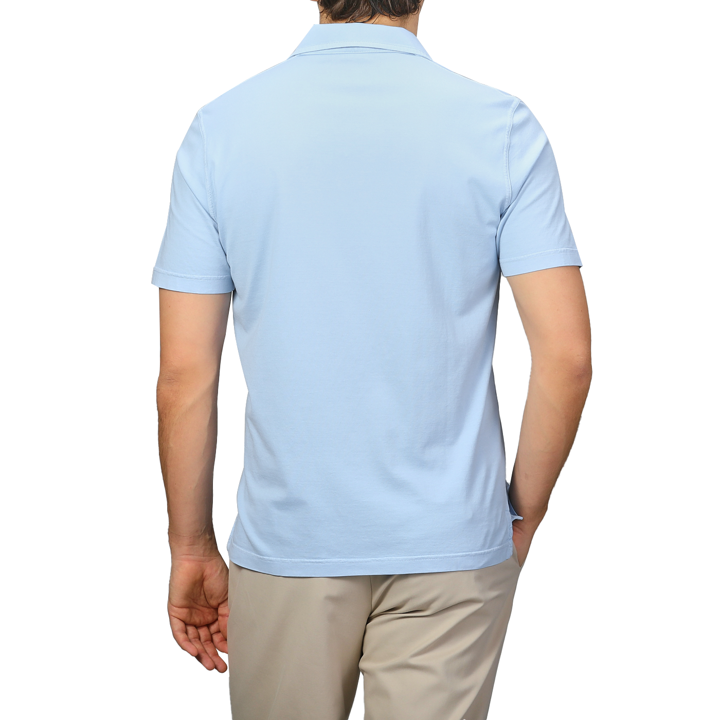 A person is seen from the back in a luxurious Fedeli light blue Capri collar polo shirt, crafted from organic cotton, paired with beige pants against a plain backdrop.