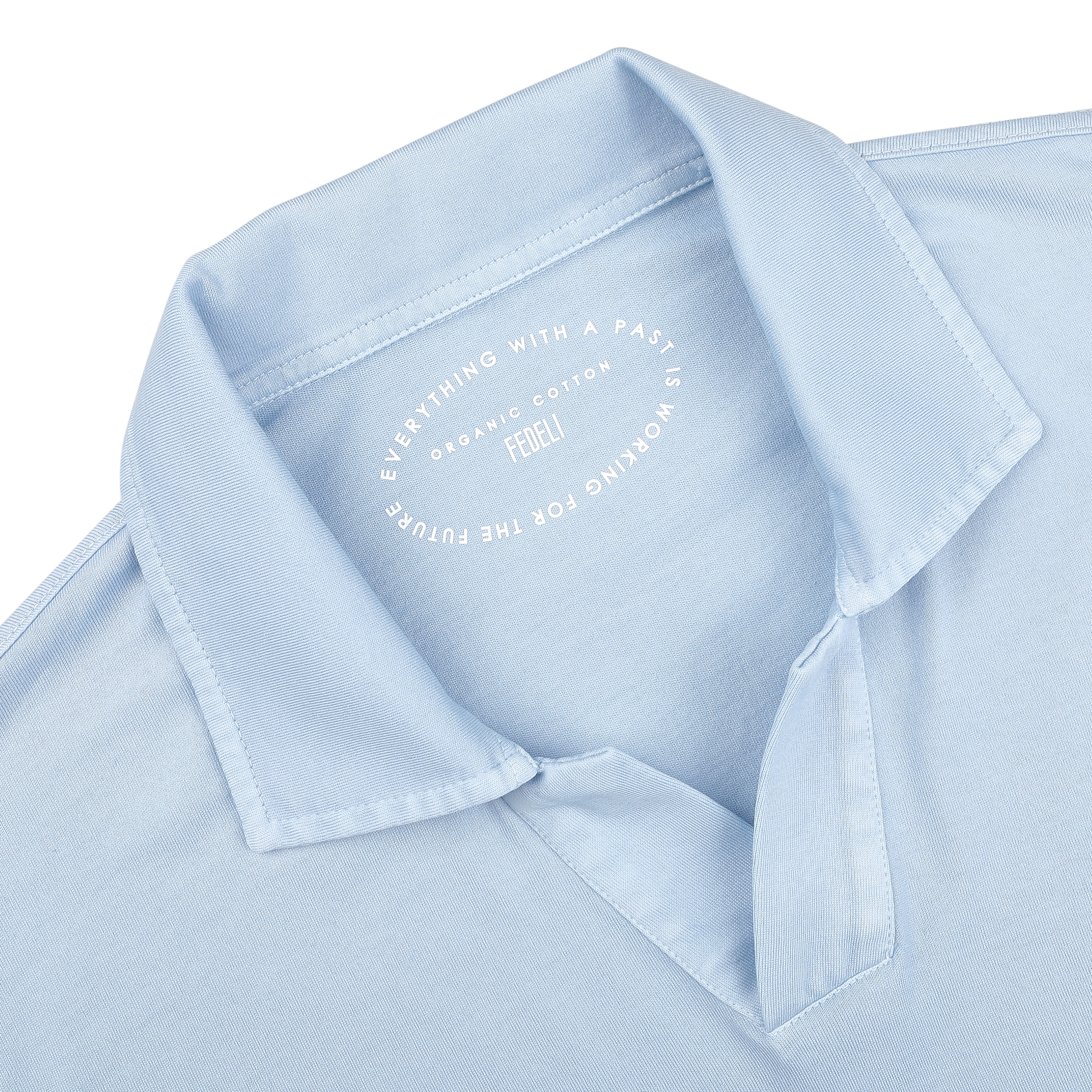 Close-up of the Light Blue Organic Cotton Capri Collar Polo Shirt by Fedeli, showcasing the text: "Everything with a past is working for the future. Fedeli. Organic Giza Cotton." This shirt epitomizes luxury casual wear.