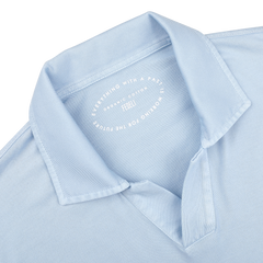 Close-up of the Light Blue Organic Cotton Capri Collar Polo Shirt by Fedeli, showcasing the text: "Everything with a past is working for the future. Fedeli. Organic Giza Cotton." This shirt epitomizes luxury casual wear.