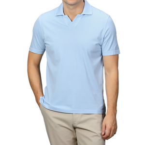 A person showcases a stylish look with Fedeli's Light Blue Organic Cotton Capri Collar Polo Shirt paired with beige pants, standing against a gray background with one hand in their pocket.