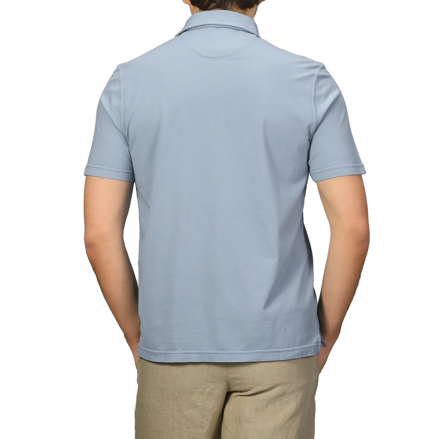 Rear view of a person in a Fedeli Light Blue Organic Cotton Polo Shirt and beige pants, standing against a plain background.