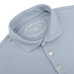 The Fedeli Light Blue Organic Cotton Polo Shirt, crafted from organic Giza cotton, showcases a circular imprint with text about organic cotton and the future.