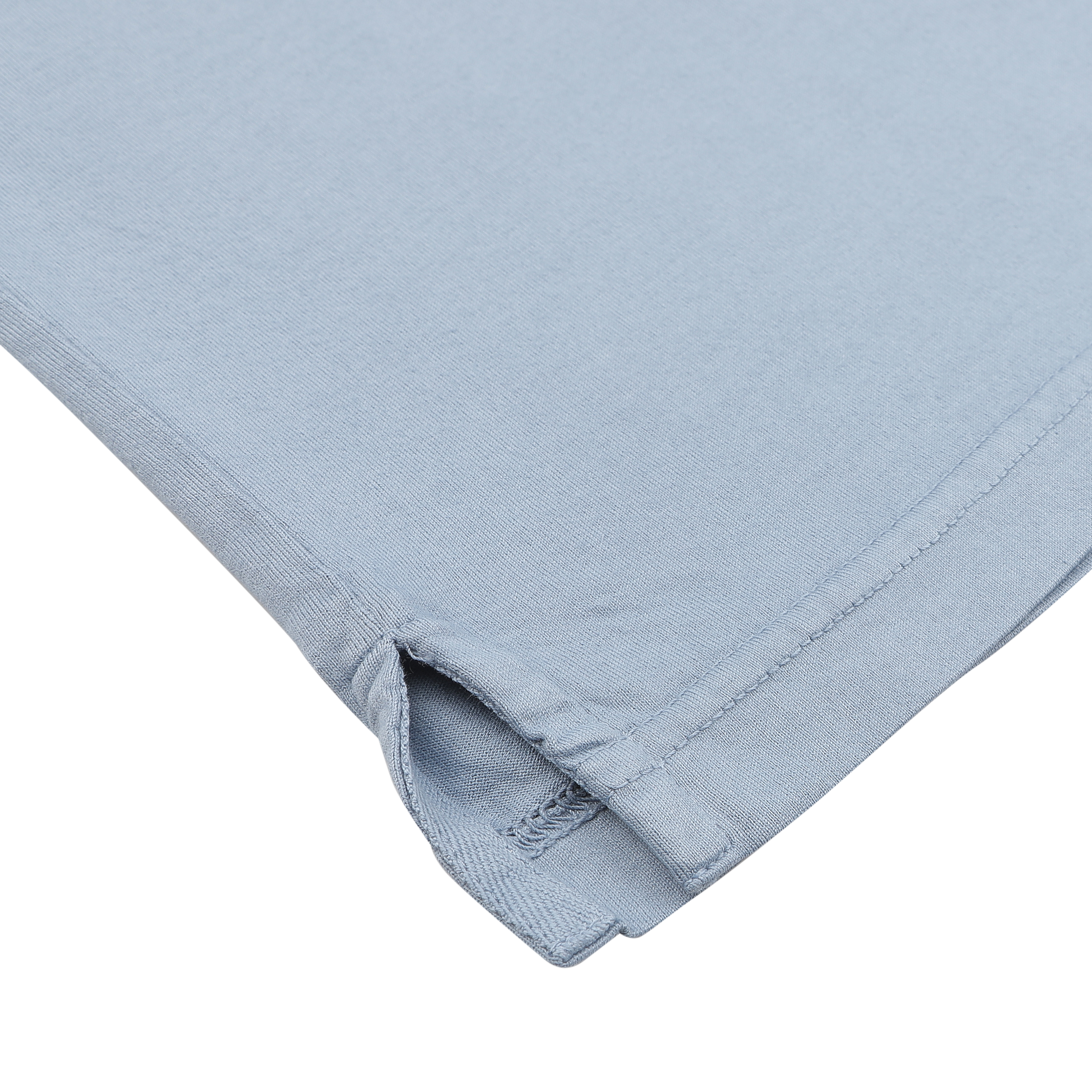 Close-up of the corner of a Fedeli Light Blue Organic Cotton Polo Shirt, showcasing the luxury casual-wear with visible stitching and a small slit, crafted from Giza cotton.