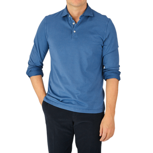A man wearing a Light Blue Organic Cotton LS Polo Shirt by Fedeli and black pants.