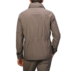 A person wearing a Fedeli Light Brown Nylon Rainproof Field Jacket and pants stands with their back to the camera against a light gray background.