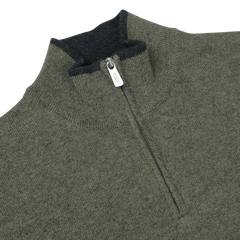 Close-up of a moss green wool-cashmere 1/4 zip sweater with a dark gray inner collar. The zipper pull is visible and labeled "Fedeli." The fabric has a knit texture.