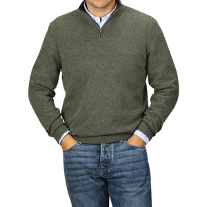 A person wearing a Moss Green Wool Cashmere 1/4 Zip Sweater from Fedeli over a light blue collared shirt and blue jeans stands with hands in pockets.