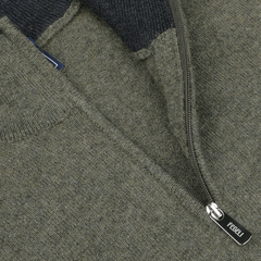 Close-up of a moss green wool-cashmere blend zip-up sweater, showcasing the zipper with a "Fedeli" branded pull tab and a portion of the fabric texture.