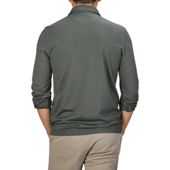 A person wearing the Fedeli Muted Green Organic Cotton LS Polo Shirt paired with beige pants, viewed from the back against a plain background.