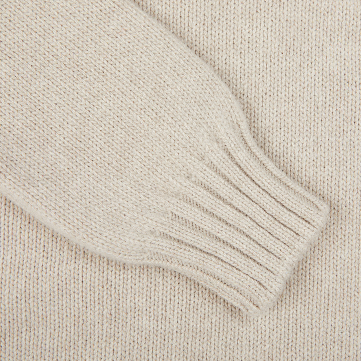 A close-up of the Fedeli Natural Beige Wool Cashmere Rollneck features a ribbed cuff on its sleeve.