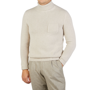 A person is wearing a Fedeli Natural Beige Wool Cashmere Rollneck with a chest pocket, paired effortlessly with light brown pants. The person's face is not visible.