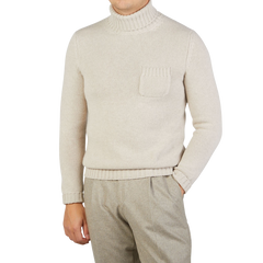 A person is wearing a Fedeli Natural Beige Wool Cashmere Rollneck with a chest pocket, paired effortlessly with light brown pants. The person's face is not visible.