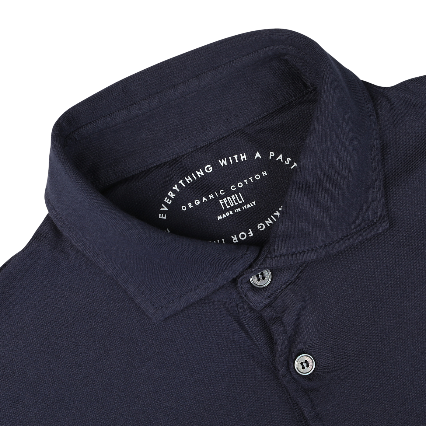 Close-up view of a navy blue, long sleeve organic cotton polo shirt collar with buttons, displaying a label that reads "Everything With a Past," "Luxury casual wear," "Fedeli," and "Made in Italy.