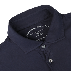 Close-up view of a navy blue, long sleeve organic cotton polo shirt collar with buttons, displaying a label that reads "Everything With a Past," "Luxury casual wear," "Fedeli," and "Made in Italy.