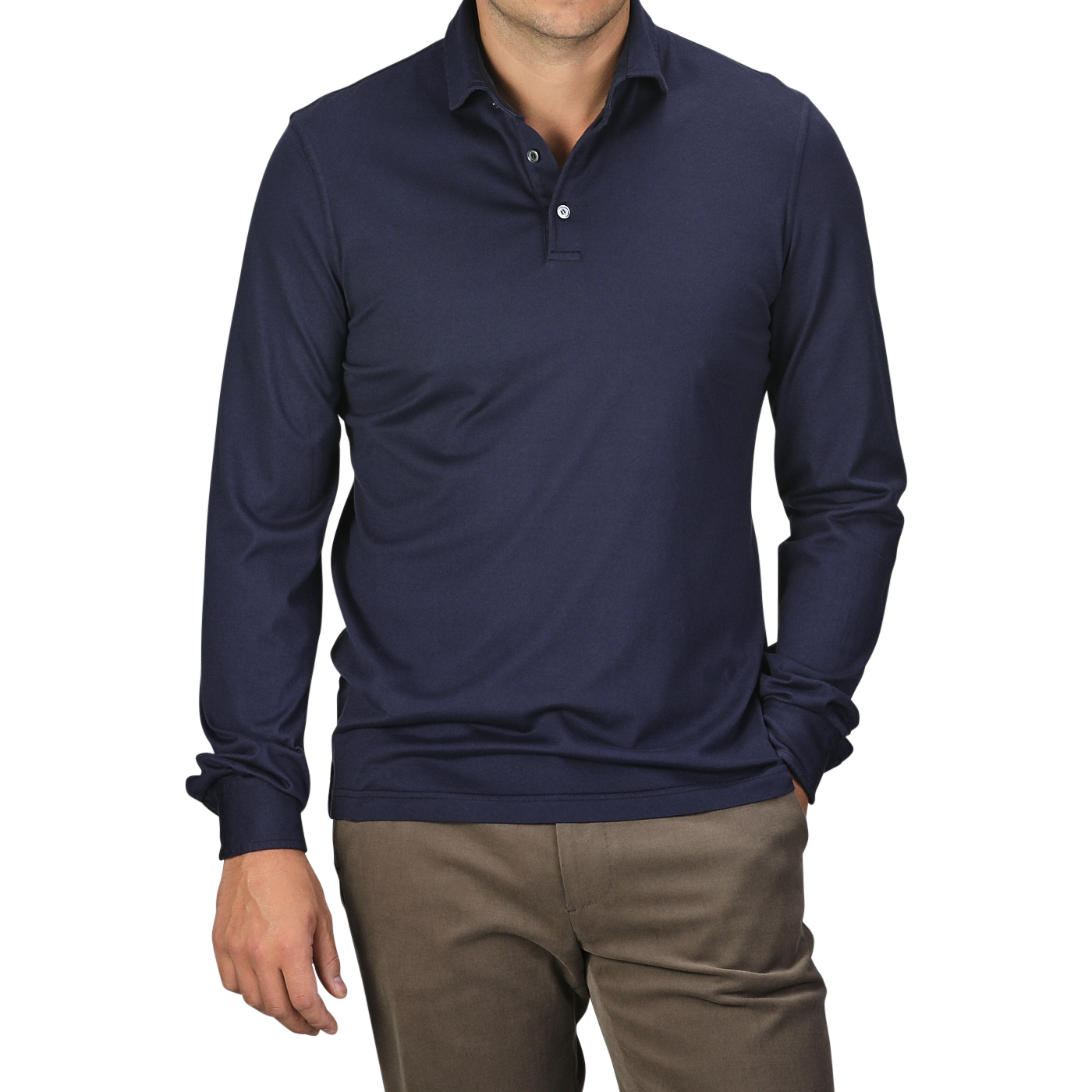 A man is wearing a Navy Blue Organic Cotton LS Polo Shirt by Fedeli and beige pants, with hands partially in pockets, epitomizing luxury casual wear.