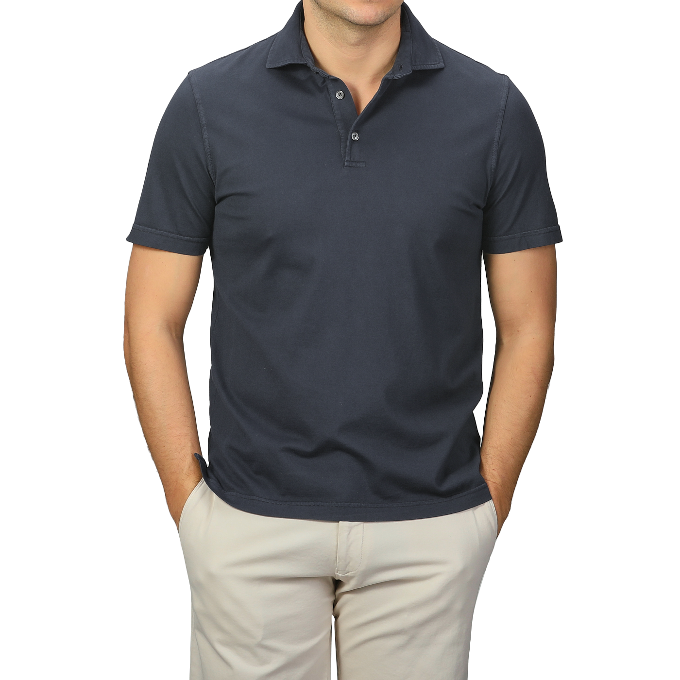 A person models a luxury casual look with hands in pockets, wearing a Fedeli Navy Blue Organic Cotton Polo Shirt and beige pants against a plain background.