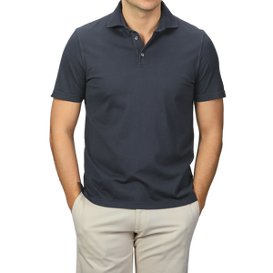 A person models a luxury casual look with hands in pockets, wearing a Fedeli Navy Blue Organic Cotton Polo Shirt and beige pants against a plain background.