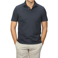 A person models a luxury casual look with hands in pockets, wearing a Fedeli Navy Blue Organic Cotton Polo Shirt and beige pants against a plain background.