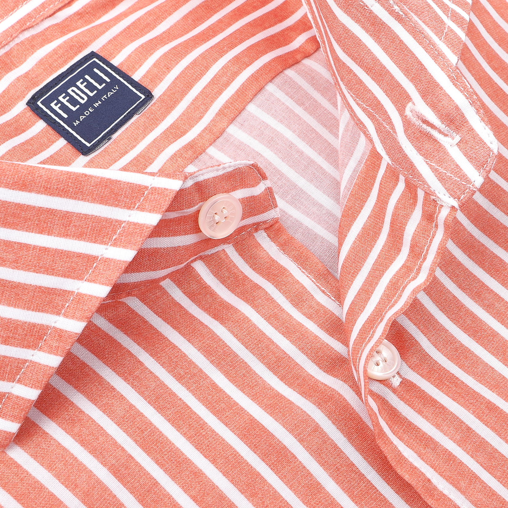 Close-up of a Fedeli orange and white striped beach shirt with white buttons. Made from cotton stretch fabric, it provides a comfortable slim fit.