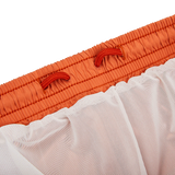A close up of a Fedeli Rust Brown Microfiber Madeira Swim Shorts in orange and white.