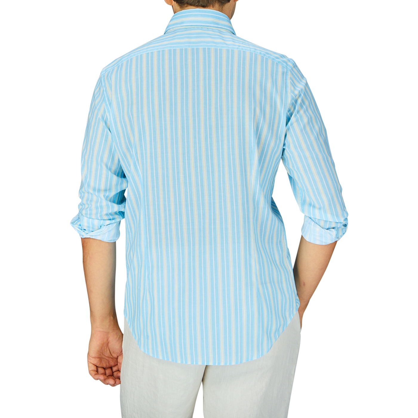 A person standing with their back to the camera, wearing a Fedeli Sky Blue Yellow Striped Cotton Beach Shirt and white pants.