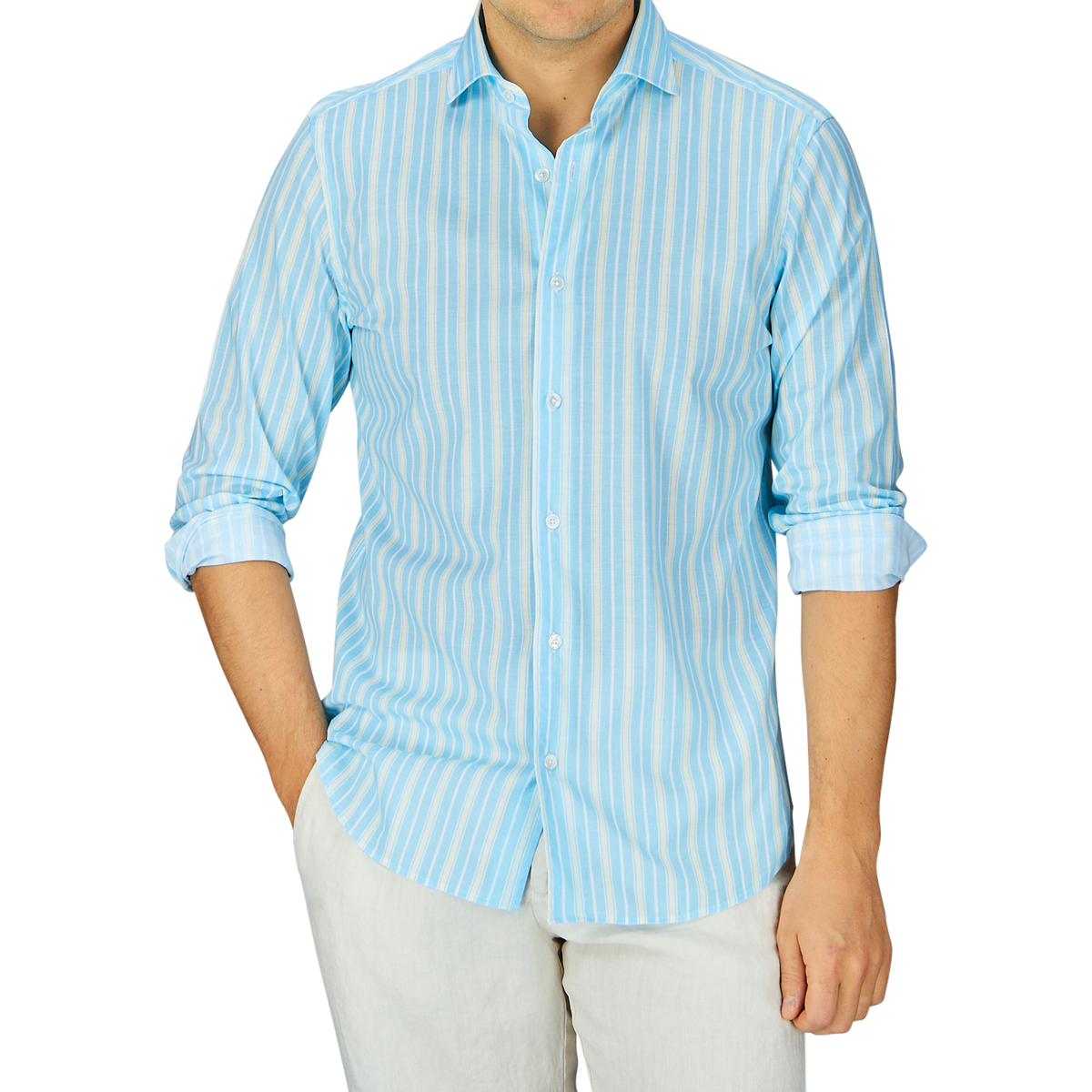 Man wearing a Fedeli Sky Blue Yellow Striped Cotton Beach Shirt, with blue and white stripes and light-colored pants against a gray background.