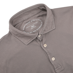 The Fedeli Taupe Beige Organic Cotton LS Polo Shirt is a luxury item with a collar and three buttons, crafted from organic Giza cotton. The inner label reads: "Everything with a past is organic cotton. Recycled for the future.