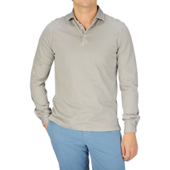 A man wearing a luxury Fedeli Taupe Beige Organic Cotton LS Polo Shirt and blue pants.